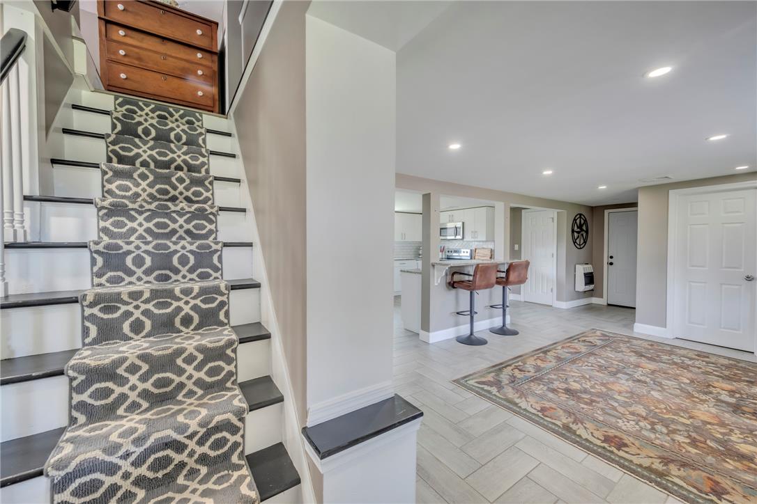 439 Cherry Hill Road Nazareth, PA 18064 - Photo 25 of 31 A striking patterned runner leads up a modern staircase, flowing into an open-concept living area with a bright kitchen beyond.