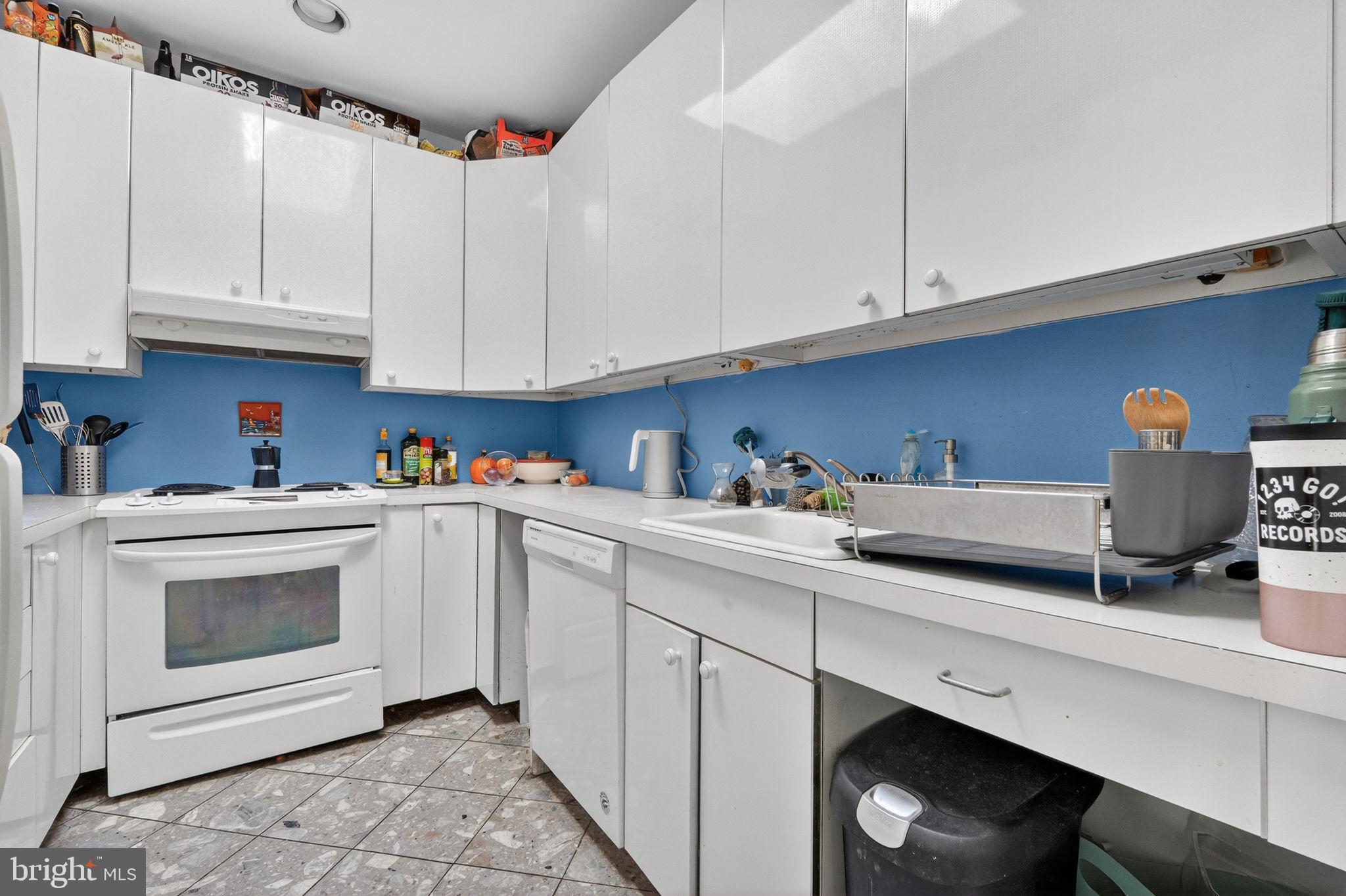 1944 Calvert Street Northwest Washington, DC 20009 - Photo 15 of 85 a kitchen with granite countertop white cabinets and white appliances