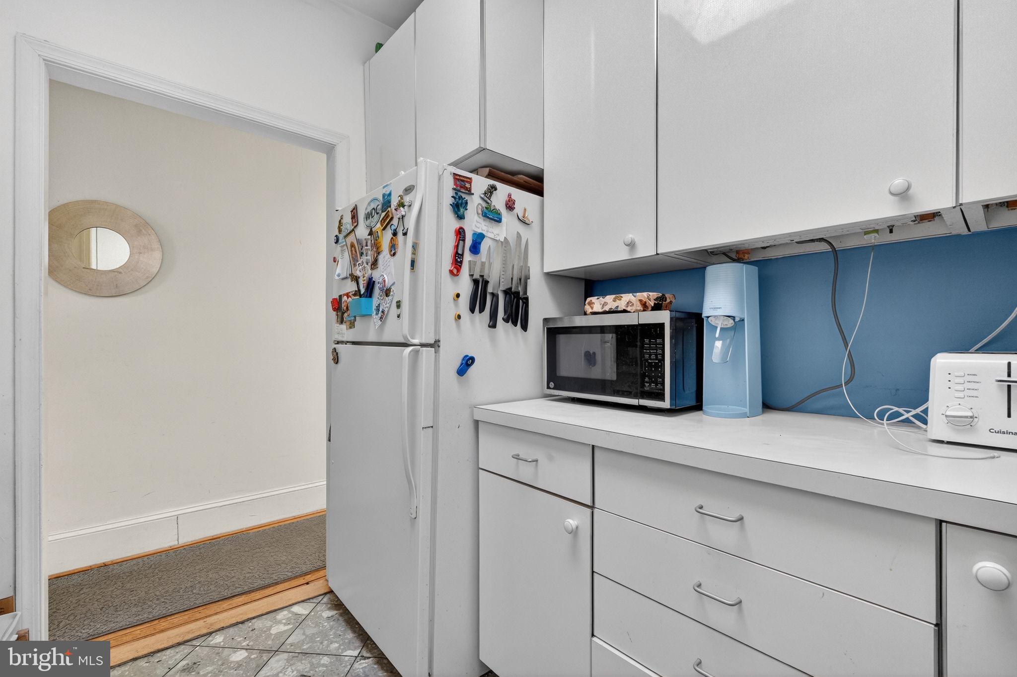 1944 Calvert Street Northwest Washington, DC 20009 - Photo 18 of 85 a kitchen with stainless steel appliances a refrigerator and cabinets