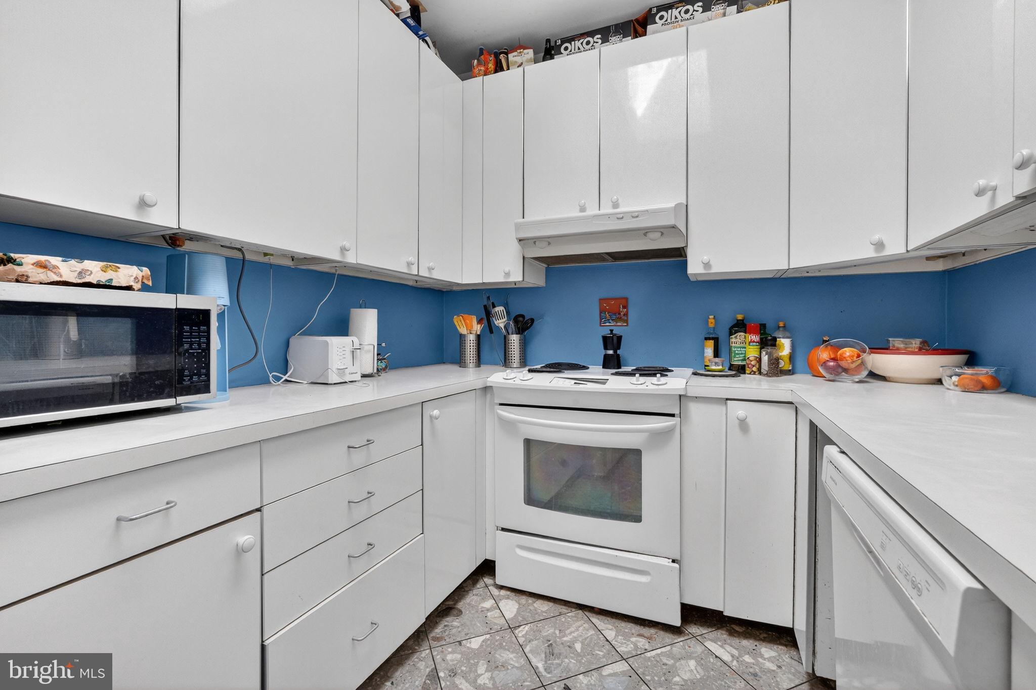 1944 Calvert Street Northwest Washington, DC 20009 - Photo 21 of 85 a kitchen with white cabinets and white appliances