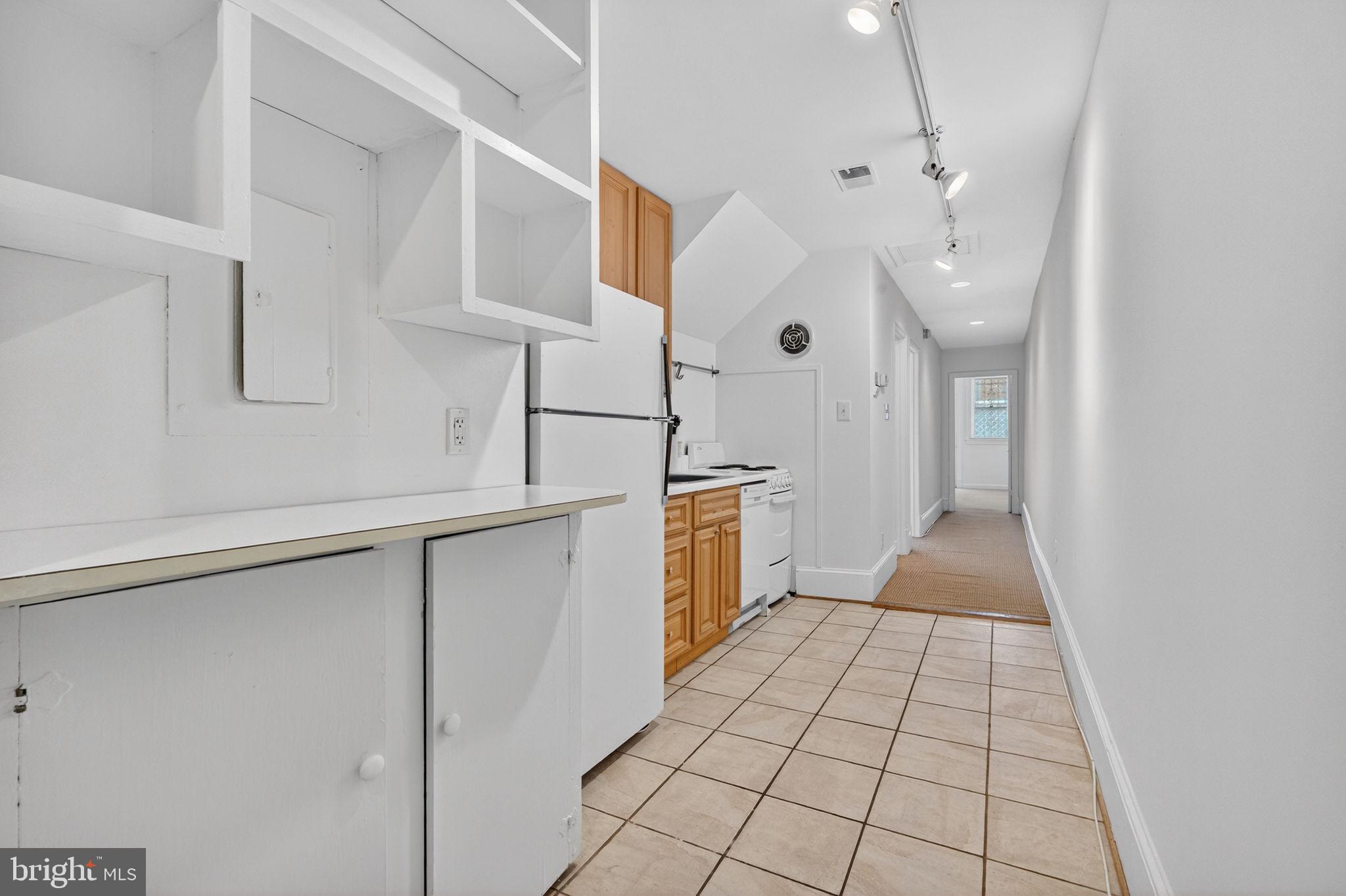 1944 Calvert Street Northwest Washington, DC 20009 - Photo 44 of 85 a kitchen with white cabinets and white appliances