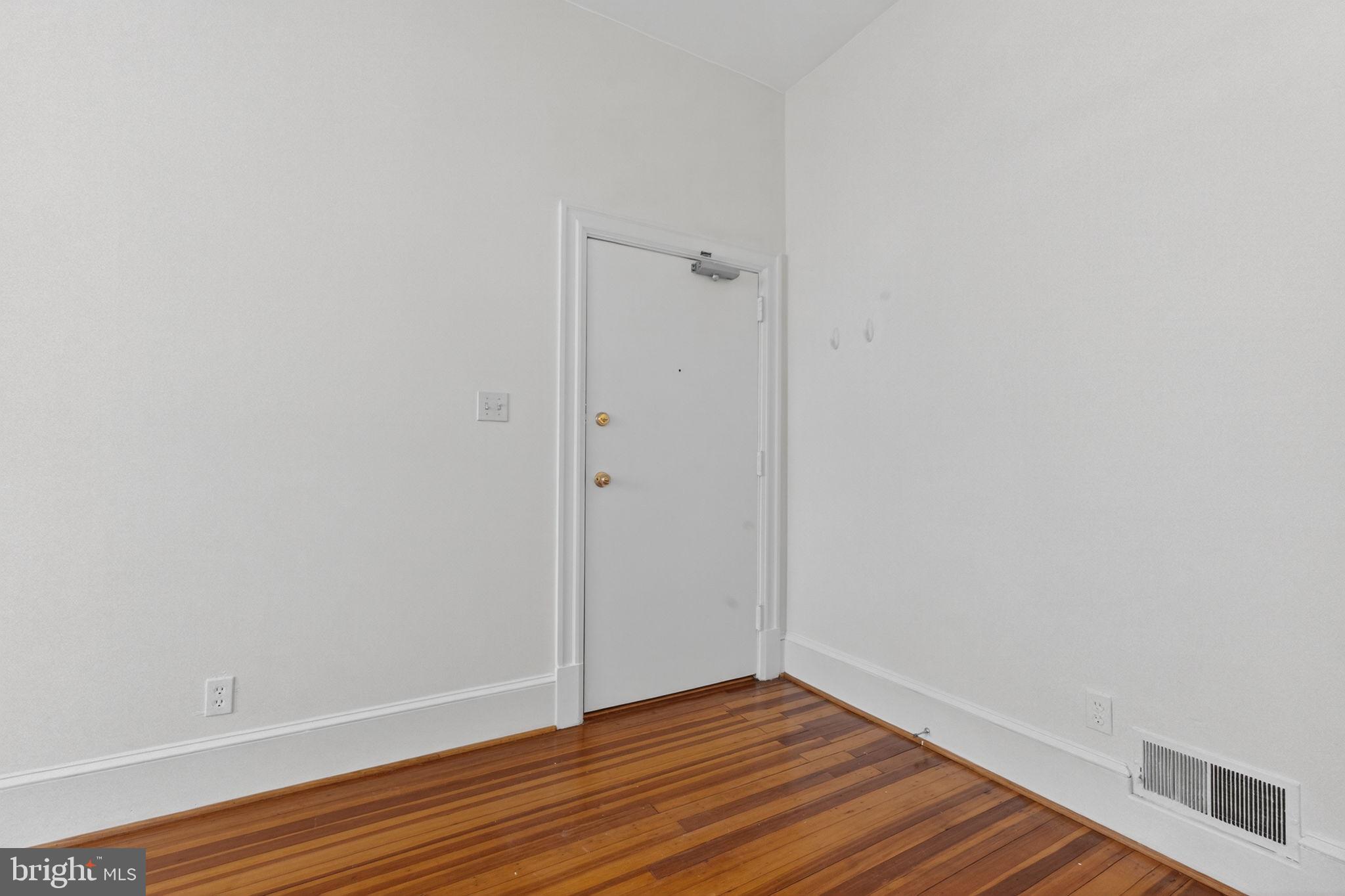 1944 Calvert Street Northwest Washington, DC 20009 - Photo 47 of 85 a view of an empty room with wooden floor