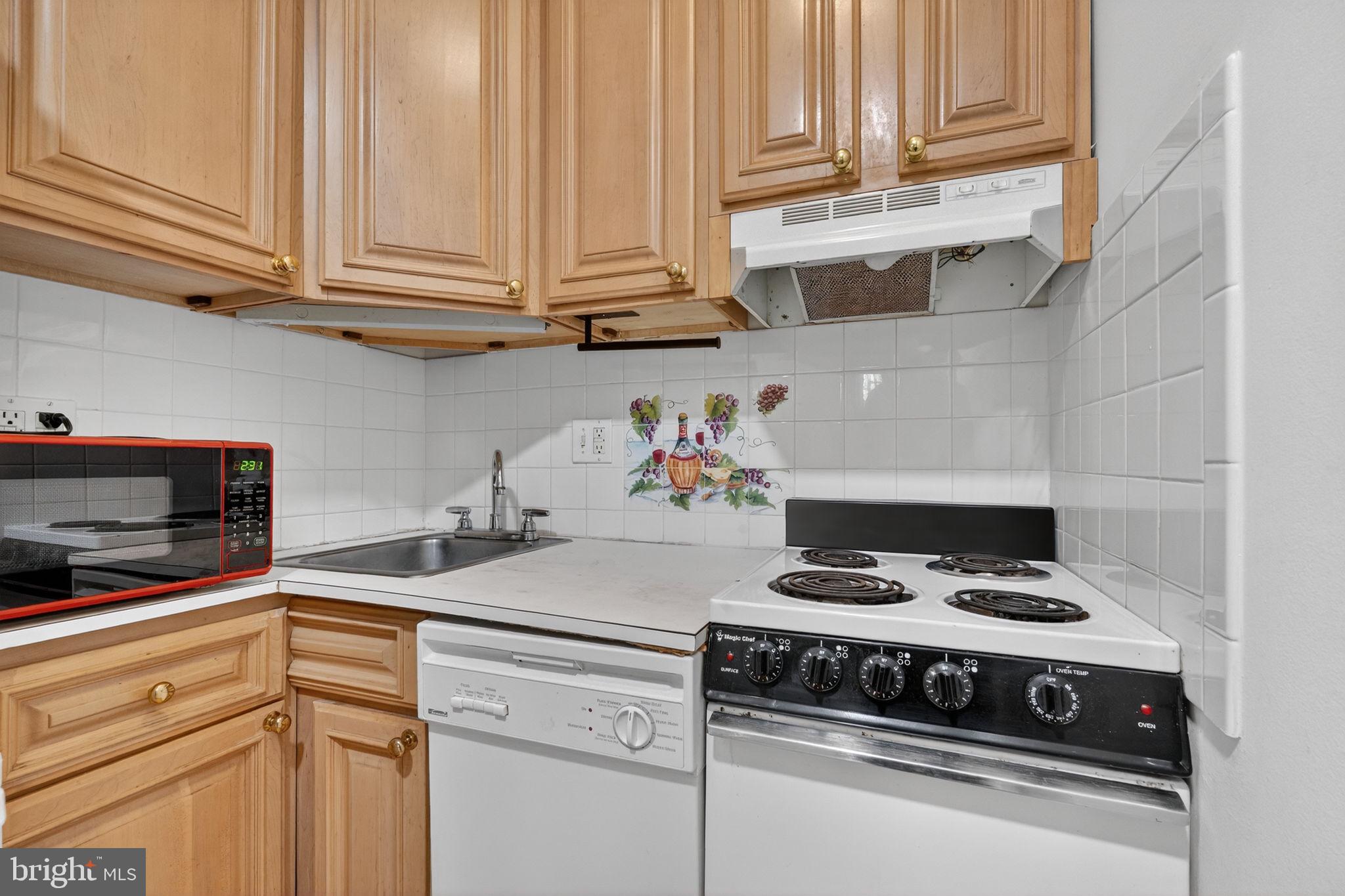 1944 Calvert Street Northwest Washington, DC 20009 - Photo 72 of 85 a kitchen with stainless steel appliances granite countertop a stove a microwave and cabinets