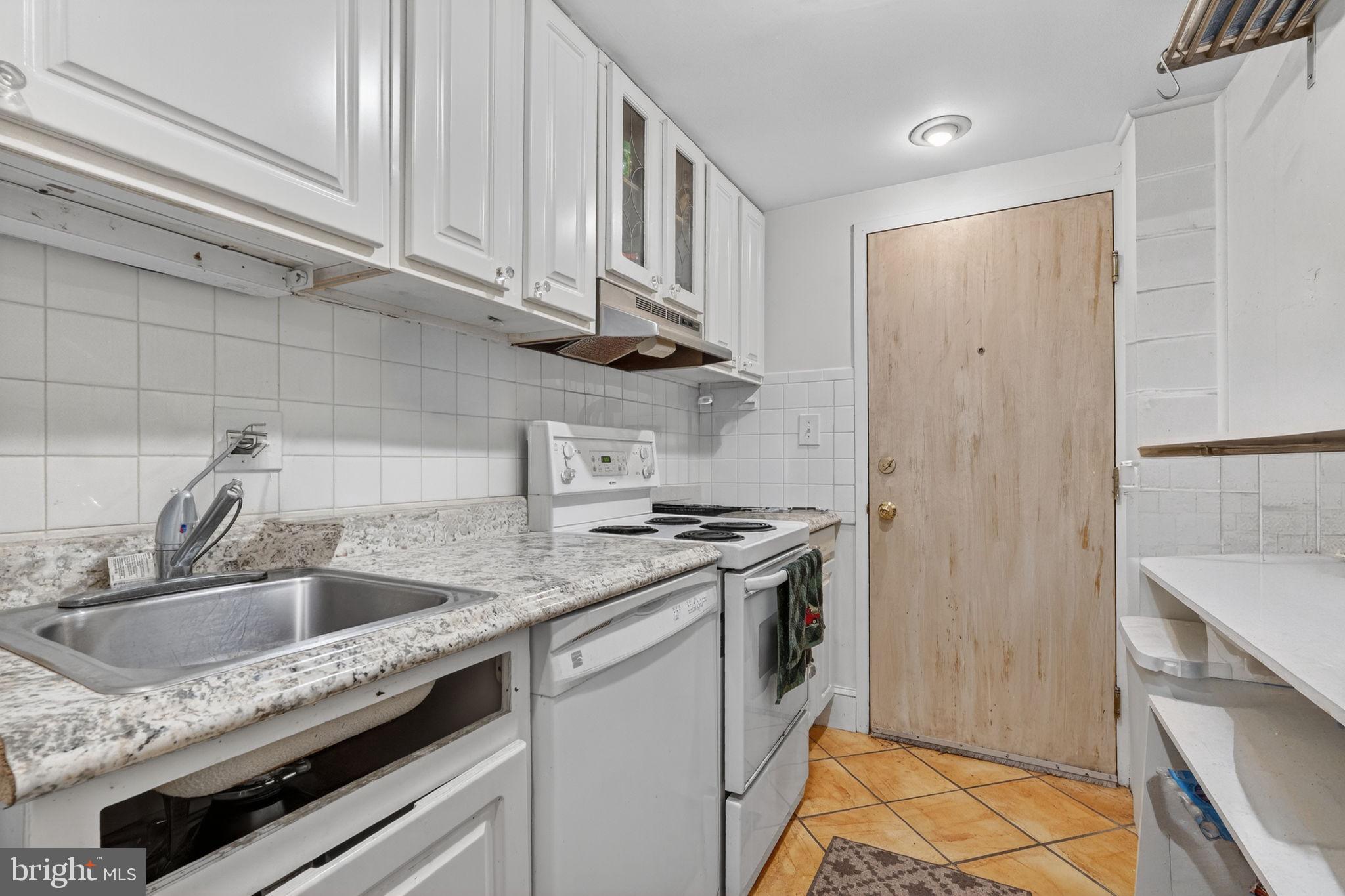 1944 Calvert Street Northwest Washington, DC 20009 - Photo 78 of 85 a kitchen with stainless steel appliances granite countertop a sink stove and refrigerator