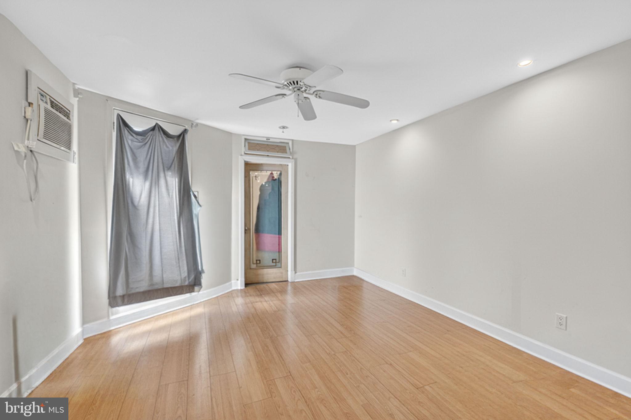 1944 Calvert Street Northwest Washington, DC 20009 - Photo 80 of 85 a view of an empty room with wooden floor and a window