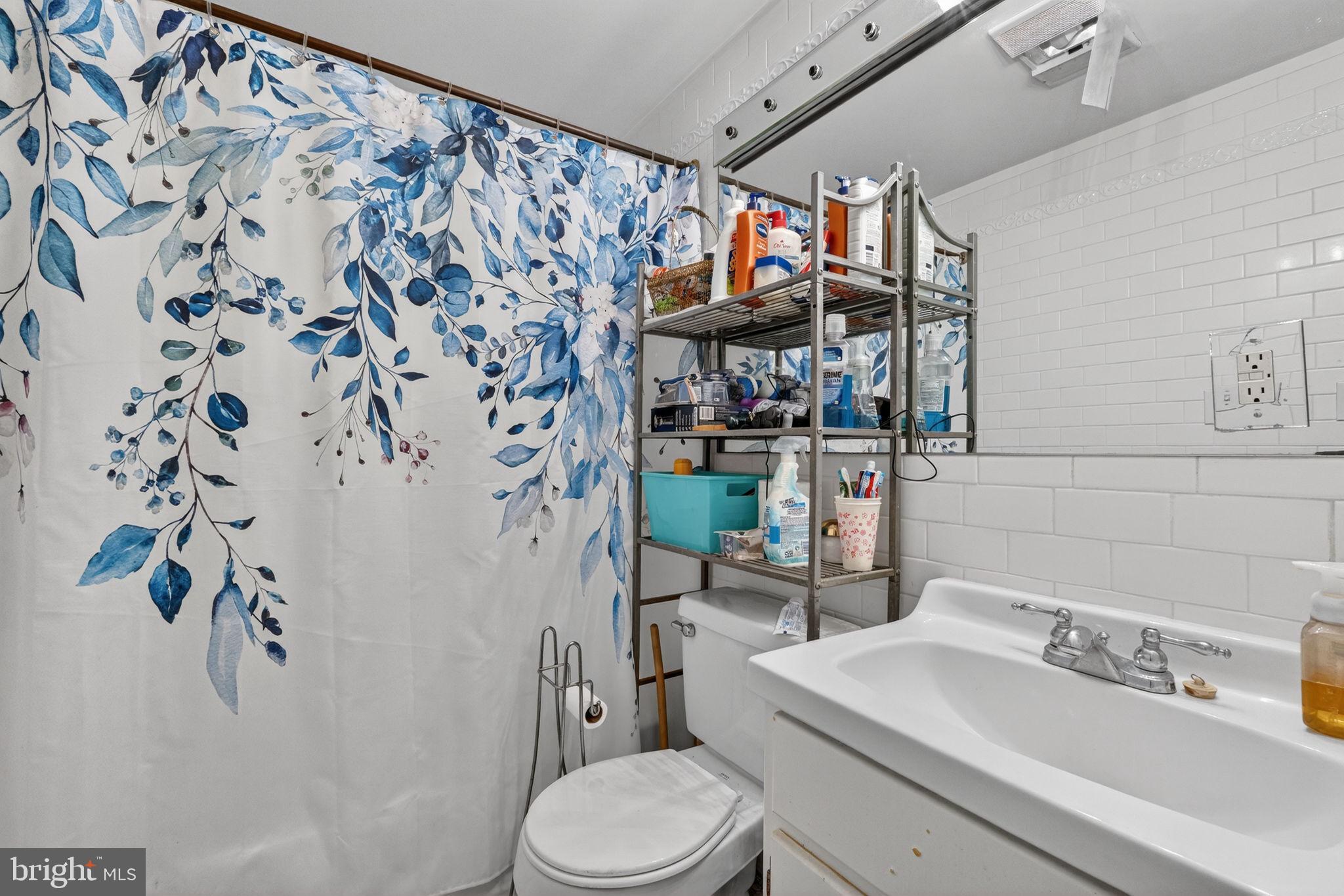 1944 Calvert Street Northwest Washington, DC 20009 - Photo 82 of 85 a bathroom with a toilet sink and shower curtain