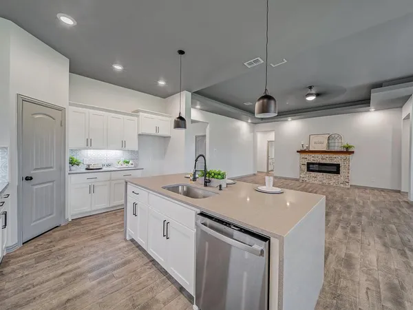 a kitchen with kitchen island a sink stainless steel appliances and cabinets