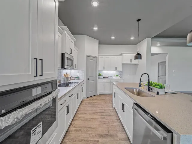 a large kitchen with stainless steel appliances lots of counter space and a sink