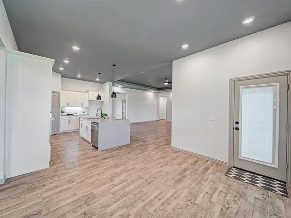 a room with kitchen island stainless steel appliances wooden floor and view living room