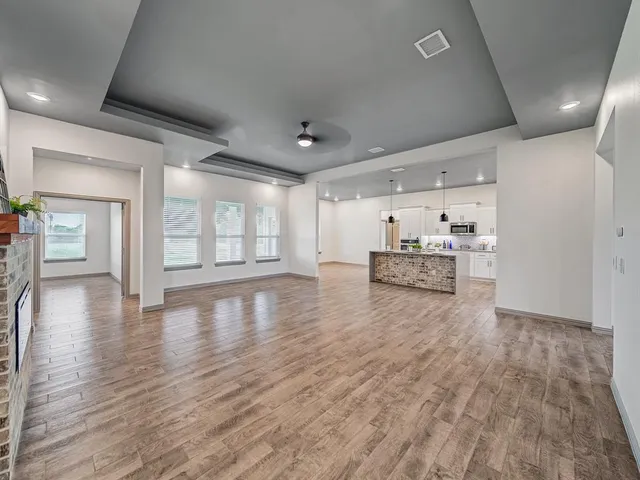 a view of a livingroom with hardwood floor and a kitchen