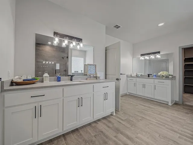a bathroom with a double vanity sink and a mirror