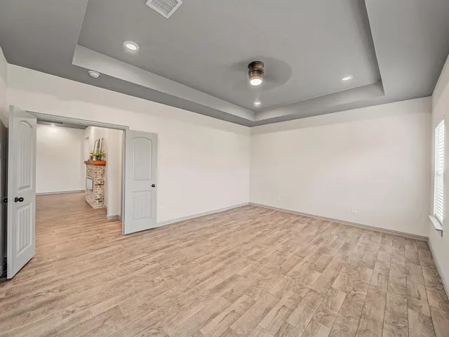 an empty room with wooden floor and bathroom