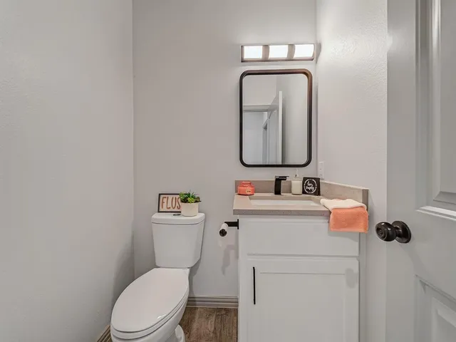 a bathroom with a toilet sink vanity and mirror