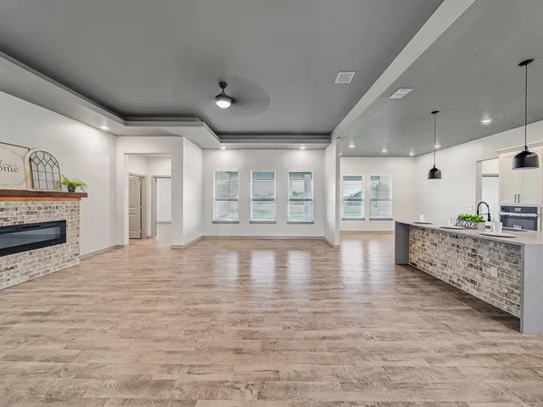 a view of an empty room with a kitchen and window