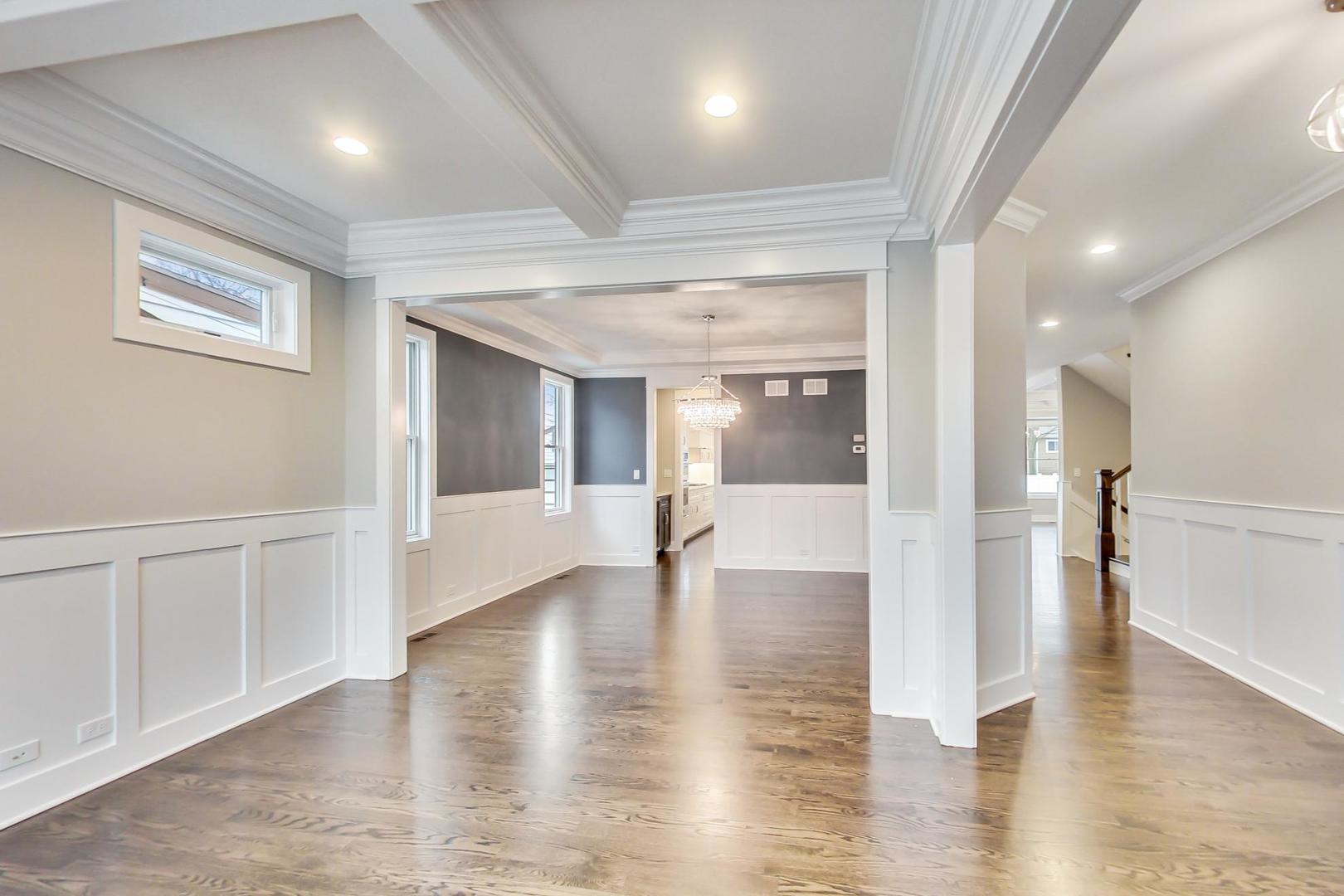 150 Avon Road Elmhurst, IL 60126 - Photo 2 of 18 an empty room with wooden floor and a kitchen