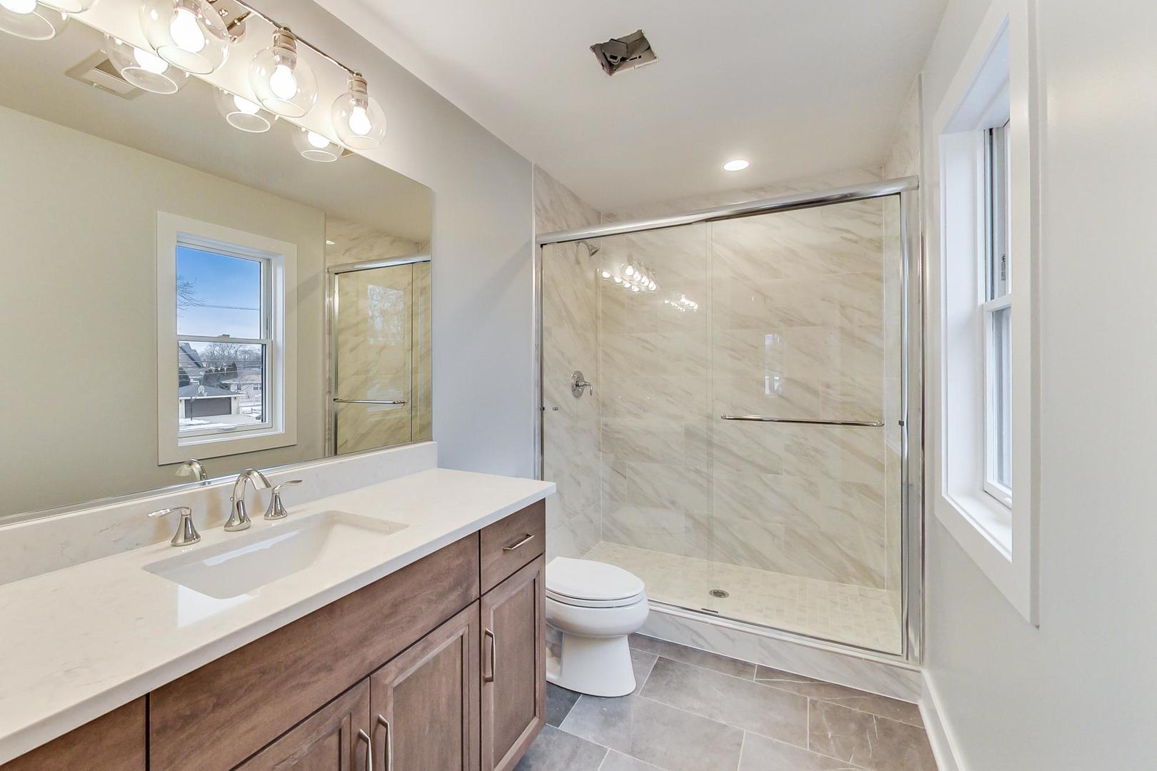 150 Avon Road Elmhurst, IL 60126 - Photo 13 of 18 a bathroom with a granite countertop sink toilet and shower