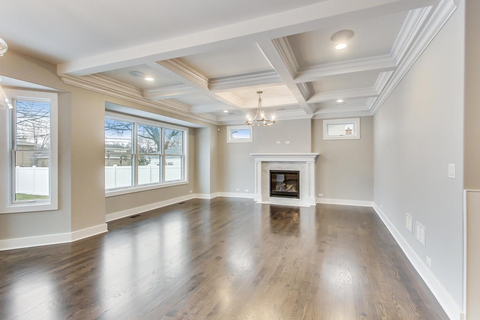 150 Avon Road Elmhurst, IL 60126 - Photo 7 of 18 an empty room with wooden floor fireplace and windows
