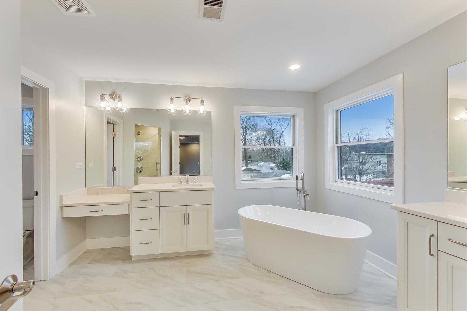 150 Avon Road Elmhurst, IL 60126 - Photo 9 of 18 a spacious bathroom with a toilet a sink a mirror a bathtub and window