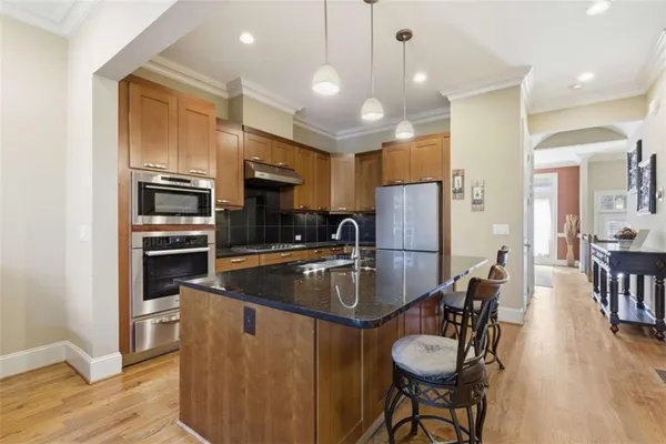 a kitchen with a dining table chairs cabinets and stainless steel appliances