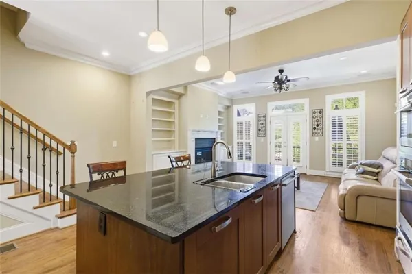 a kitchen with granite countertop a sink a counter space appliances and cabinets