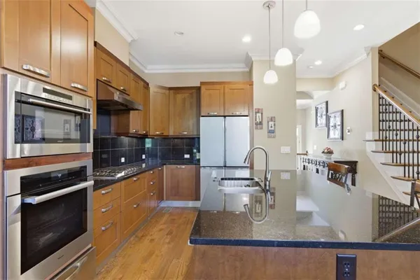 a kitchen with granite countertop a refrigerator and a stove top oven