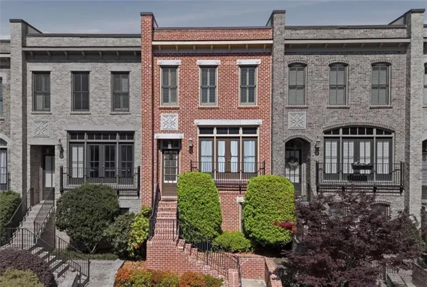 a front view of a building with balcony and garden with plants