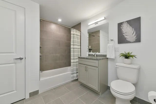 a bathroom with a granite countertop toilet a sink and bathtub