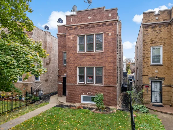 front view of a brick house with a yard