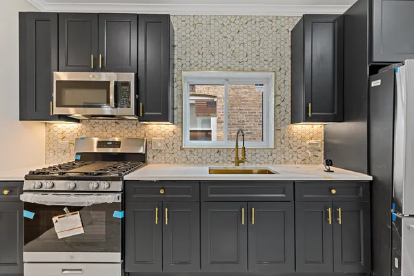 a kitchen with stainless steel appliances a stove microwave and refrigerator