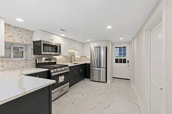 a kitchen with stainless steel appliances granite countertop a refrigerator stove microwave and sink
