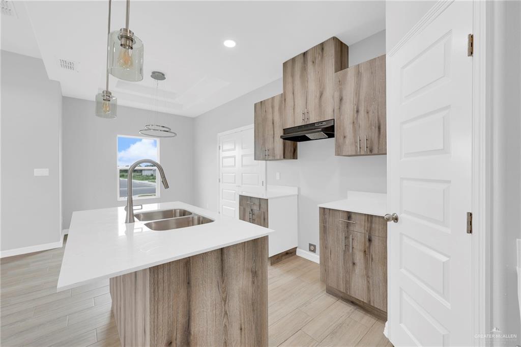 516 Bridget Street Weslaco, TX 78596 - Photo 11 of 24 a kitchen with stainless steel appliances a sink dishwasher stove refrigerator and microwave with wooden floor