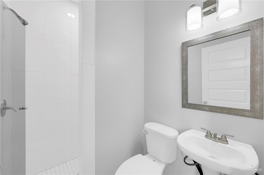 516 Bridget Street Weslaco, TX 78596 - Photo 15 of 24 a white toilet sitting next to a bathroom sink