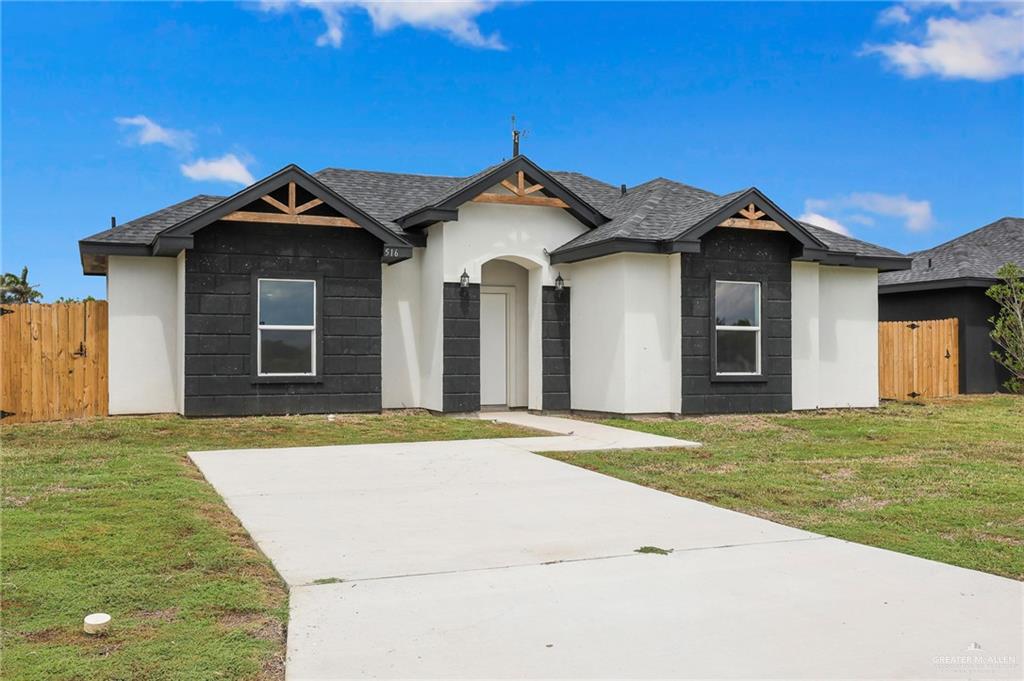 516 Bridget Street Weslaco, TX 78596 - Photo 2 of 24 a white house with a small yard and wooden fence
