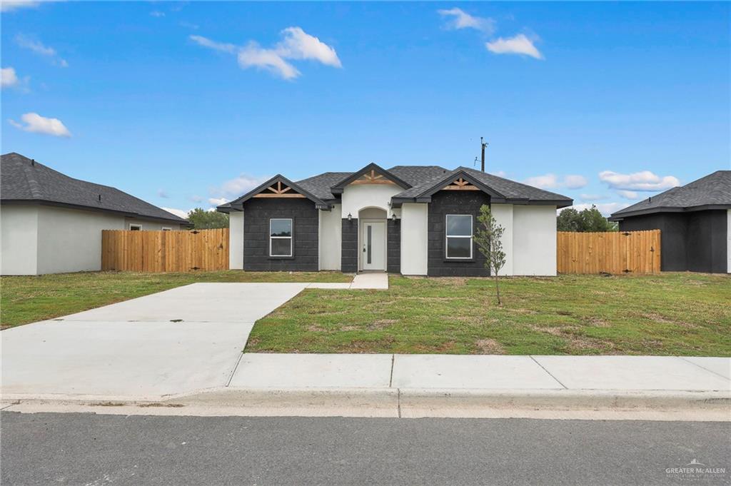 516 Bridget Street Weslaco, TX 78596 - Photo 3 of 24 a front view of a house with a yard and garage