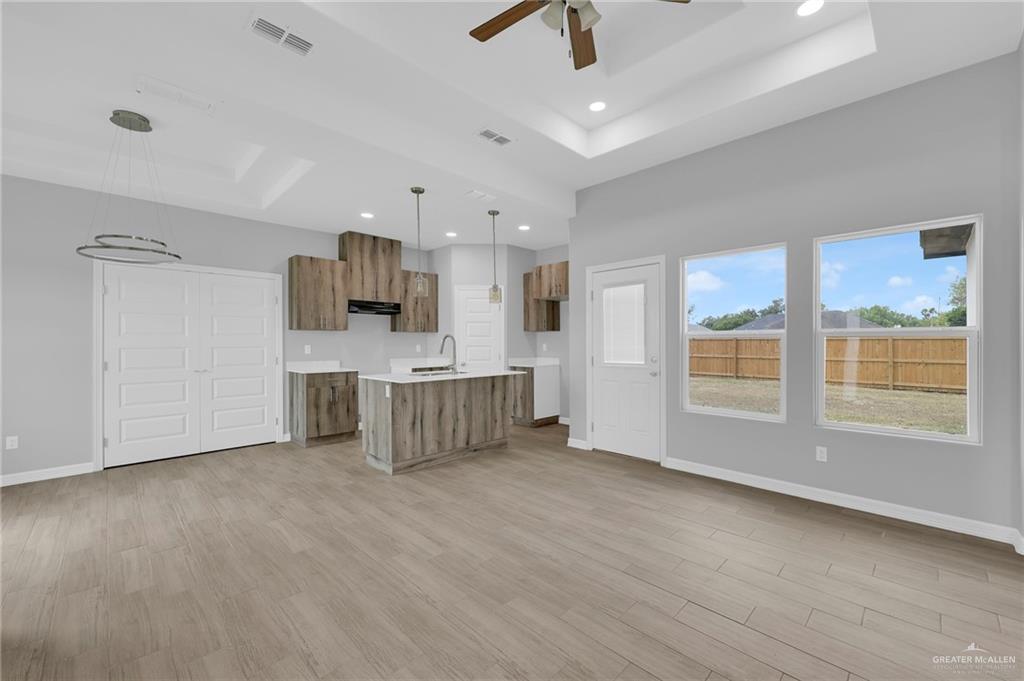 516 Bridget Street Weslaco, TX 78596 - Photo 4 of 24 a large white kitchen with stainless steel appliances kitchen island granite countertop a large window a oven and white cabinets