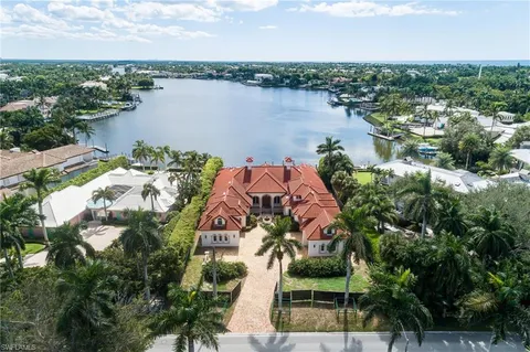 an aerial view of a house with outdoor space and lake view in back
