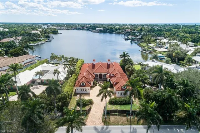 an aerial view of a house with outdoor space and lake view in back