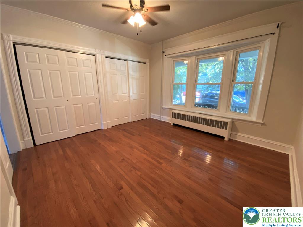 231 East Goepp Street, Unit 1 Bethlehem, PA 18018 - Photo 5 of 9 an empty room with wooden floor fan and windows