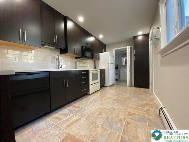 a large kitchen with a large counter top stainless steel appliances and cabinets