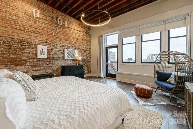 a bedroom with a bed a balcony a flat screen tv and a couch