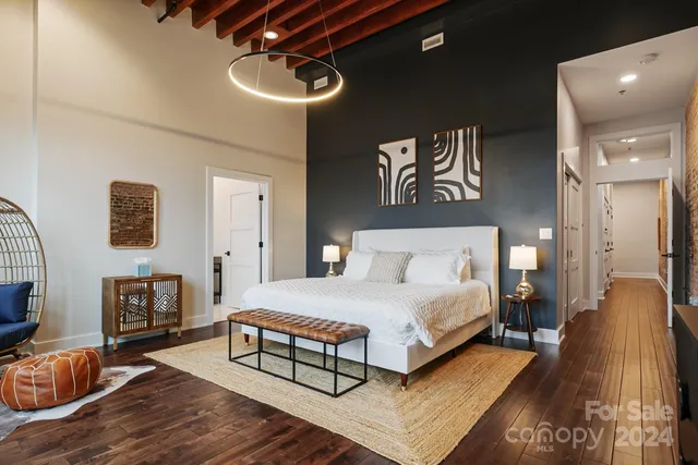 a spacious bedroom with a bed a couch and a chandelier