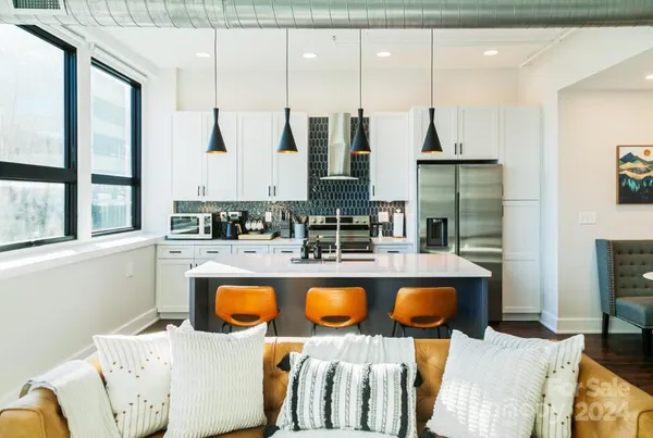a kitchen with stainless steel appliances granite countertop a sink and a refrigerator