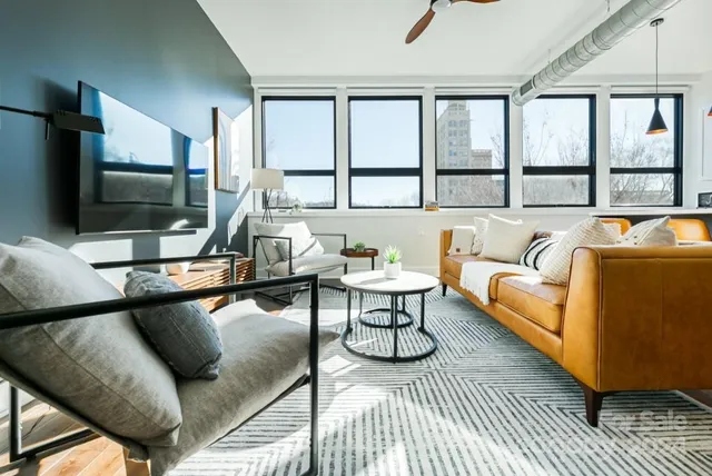 a living room with furniture a flat screen tv and a large window