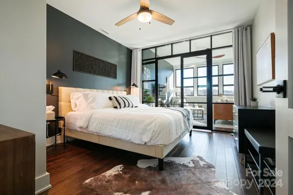 a bedroom with a bed and a flat tv screen on dresser