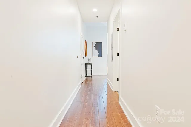 a view of a hallway with wooden floor