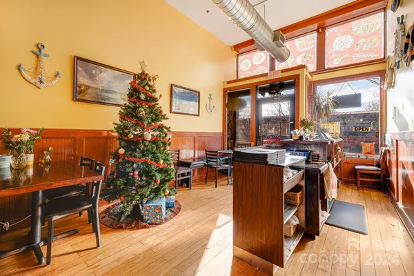 a living room with furniture a dining table with wooden floor and a potted plant
