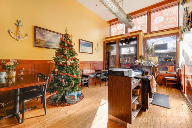 a living room with furniture a dining table with wooden floor and a potted plant