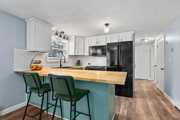 a kitchen with stainless steel appliances granite countertop a stove a sink a refrigerator and a microwave