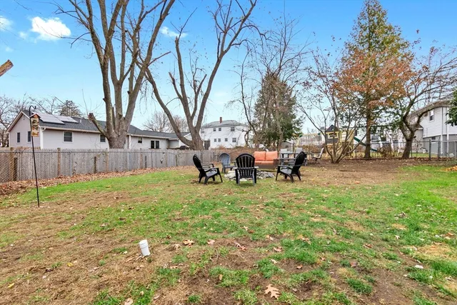 a view of a backyard with table and chairs and a large tree