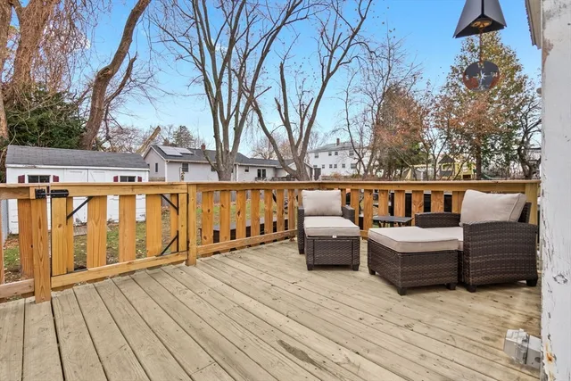 a view of a roof deck with couches and wooden fence
